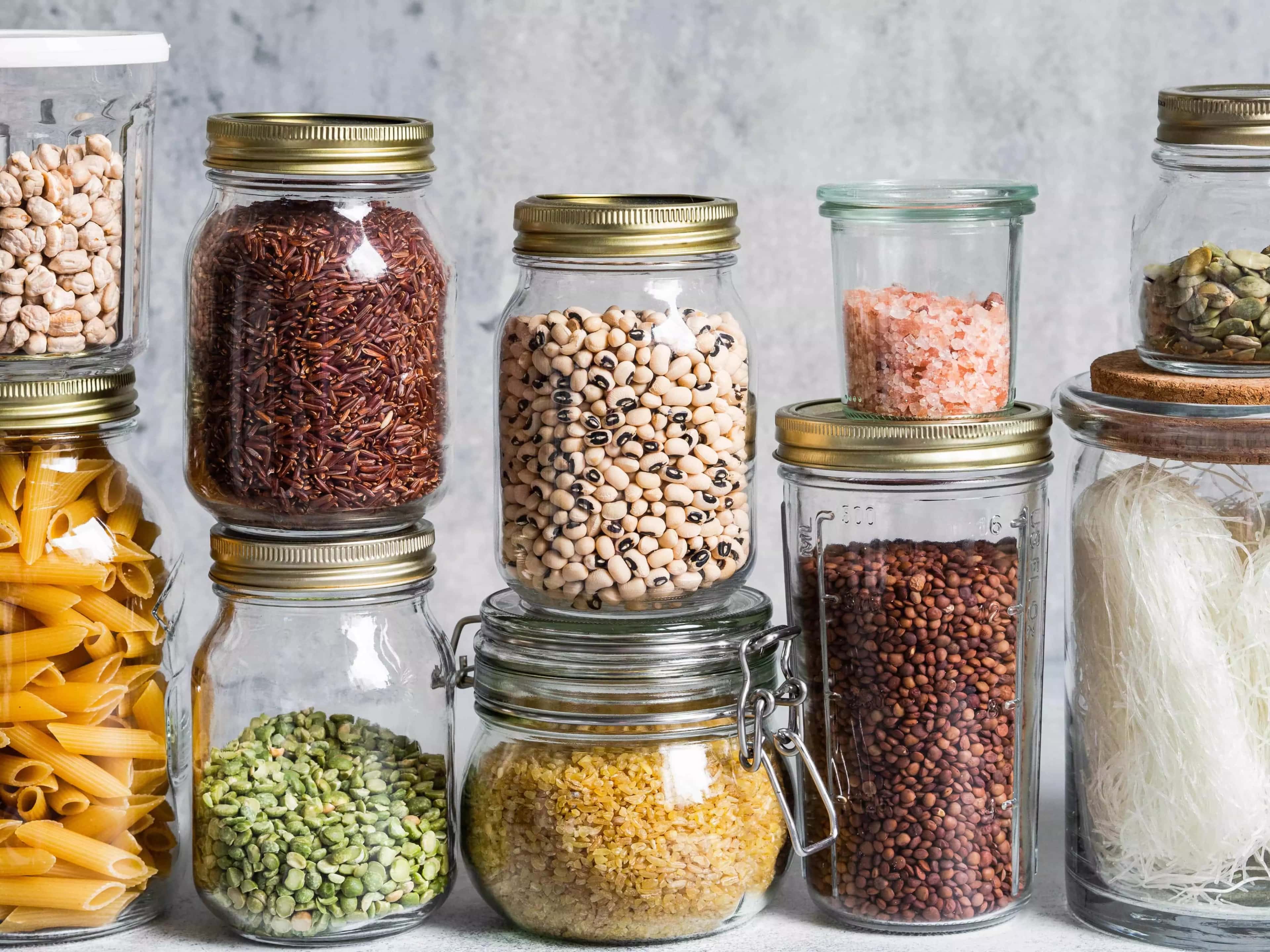 Vários potes de vidro composto por alimentos. Há opção orgânica, vegetariana, vegana, etc. Tem potes preenchidos por sal do himalaia, feijão de corda, ervilha seca partida, arroz vermelho, arroz integral e amendoim vermelho.